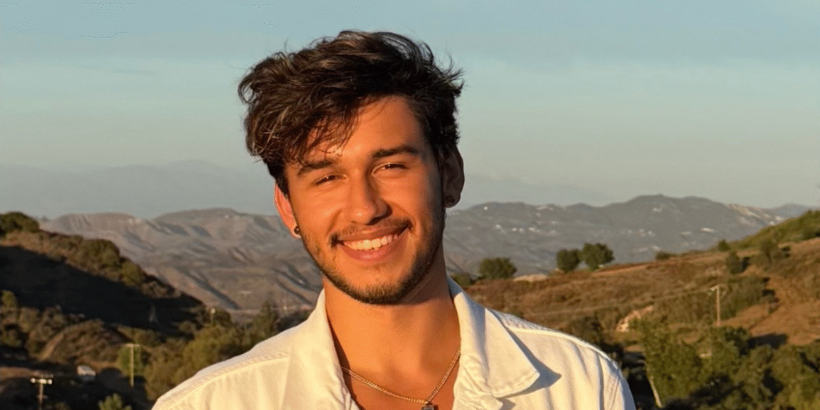 Tim, a multifaceted entertainer from Redondo Beach, California, smiling outdoors with a scenic background. A self-taught musician turned actor, model, and producer, Tim’s diverse talents span across music, film, theater, and fashion, showcasing his versatility and passion for creative expression