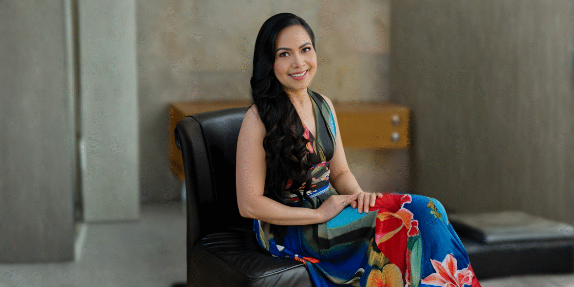 Liza Baliad, founder of Renew by Liz, seated in a vibrant dress, embodying beauty, purpose, and sustainable skincare