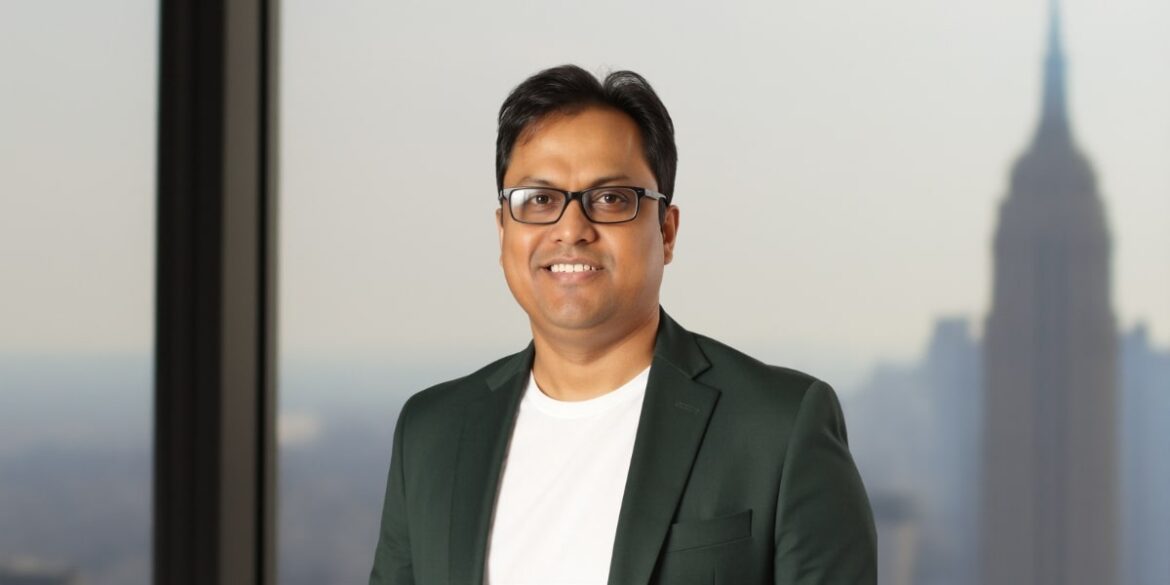 Dr. Srikumar Nayak, a pioneer in AI for financial crime prevention, standing in front of a city skyline.