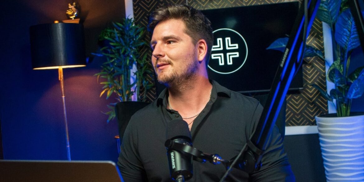 David Peter Mayer, founder of Capital Creator, speaks on real estate investment at a microphone in a modern studio.