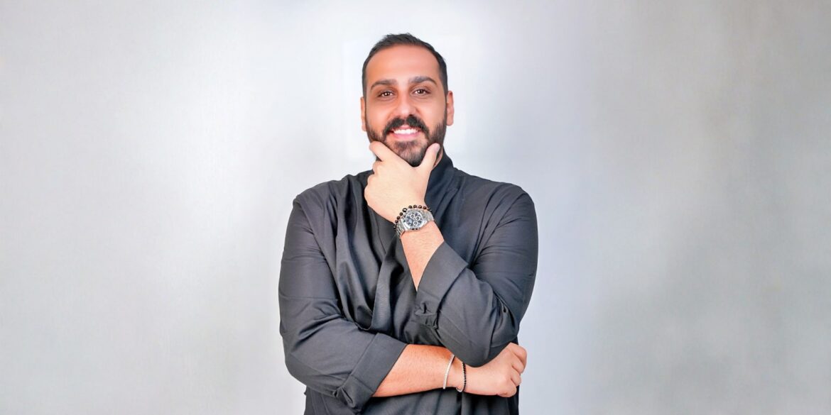 Elie El-Khoury, a data-driven digital marketing leader, confidently poses in a professional, creative setting with a watch.