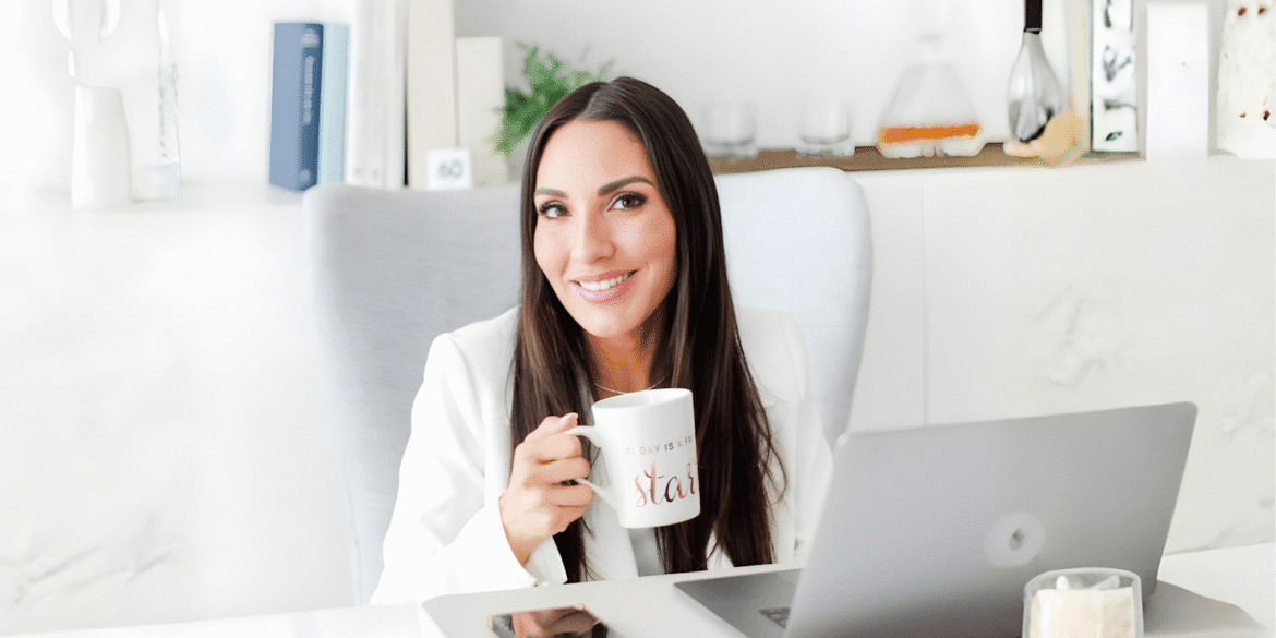 "Diana Marcela, LMFT, seated in her office with a laptop and coffee, representing her holistic, client-centered leadership at Curated Coaching and Counseling."