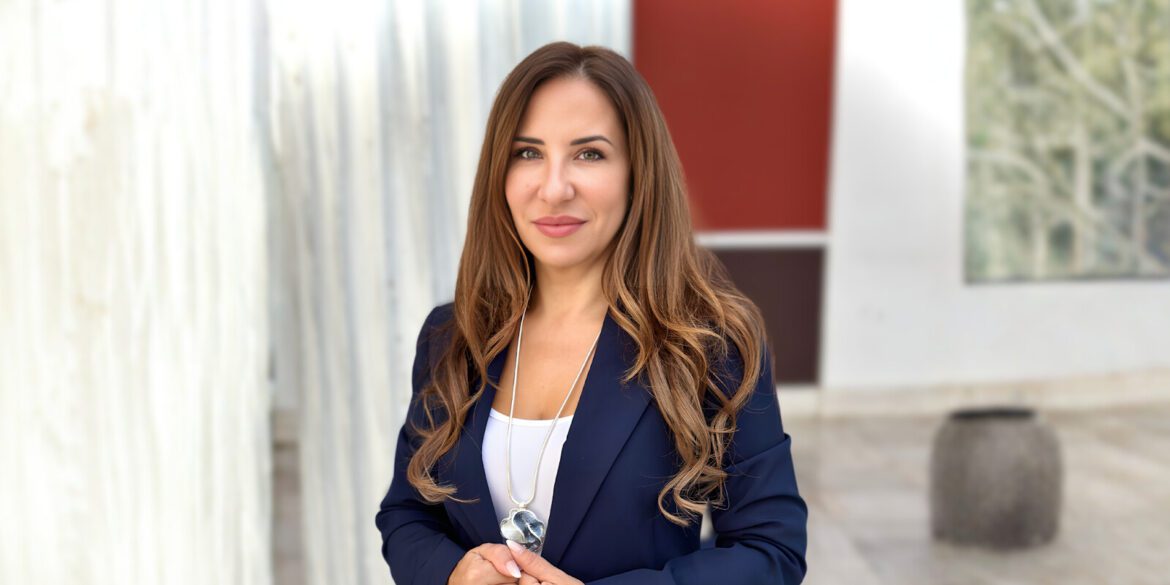 Dr. Barbara Geladakis, founder of RODI Fertility, standing confidently in a navy suit, with a professional expression.