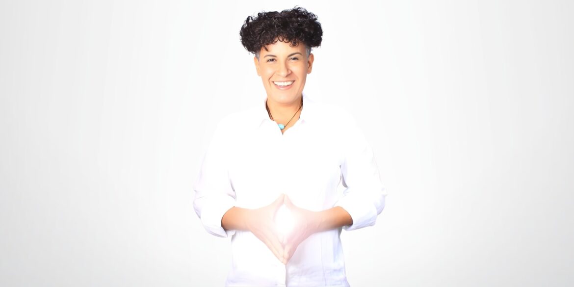 A smiling woman with curly hair, dressed in white, embodies Naima Nouidjem’s Power Coaching Formula for personal transformation.