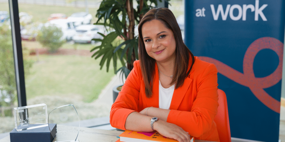 Lauren Neal in a professional setting with awards, showcasing Valued at Work’s leadership impact.
