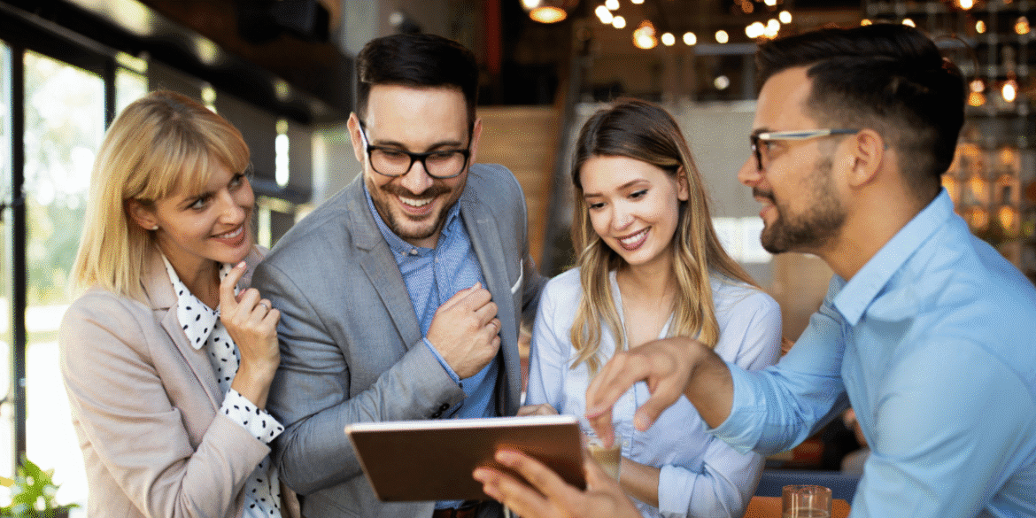 Four professionals discussing ideas, collaborating in a modern office space, embodying global communication and teamwork for growth.