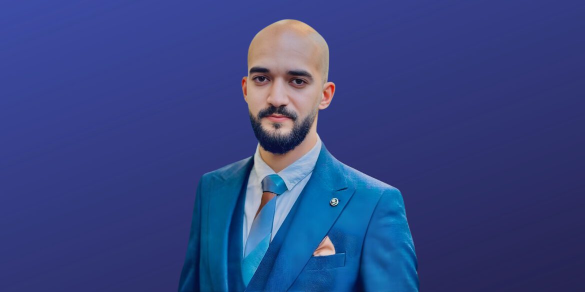 Taher Amine ELHOUARI in a blue suit, embodying leadership in cybersecurity with a strategic, resilient approach.