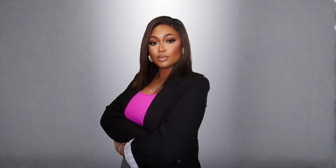 Osas Imafidon, the founder of The Enjoyment Minister, posing confidently in a professional outfit.