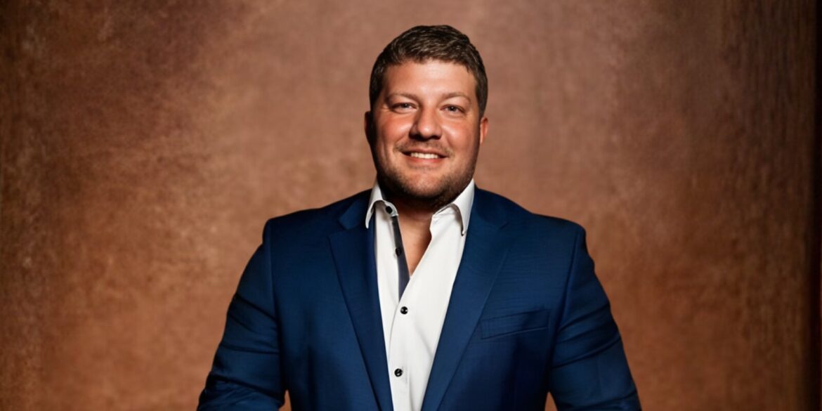 A man in a blue suit and white shirt stands confidently, representing professionalism in the real estate industry.