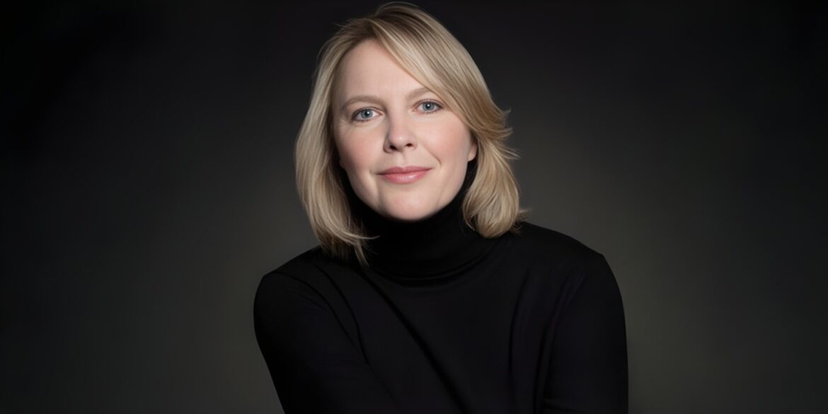 A person with shoulder-length blonde hair in a black turtleneck smiles gently against a dark background, conveying a calm and confident tone.