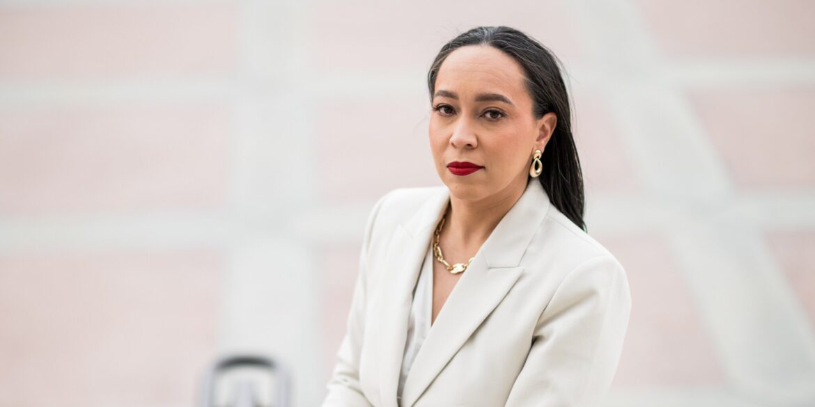 Tina Patterson in a white suit with red lipstick, exuding confidence as she discusses strategic legal counsel for leaders.
