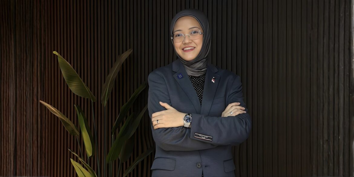 Miss Miza Abdul Halek, founder of Bespoke Capital, standing confidently with arms crossed, wearing a professional suit.