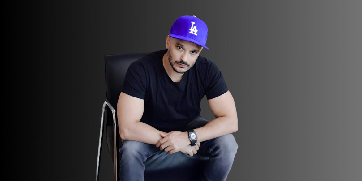 "Imran Nizami, founder of SEOGorillas, sitting confidently in a chair wearing a purple LA cap, showcasing his leadership.