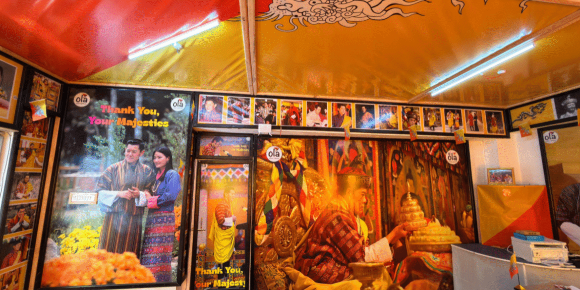 Close-up of Ola Tours’ “Thank You, Your Majestics” poster with a Bhutanese couple.