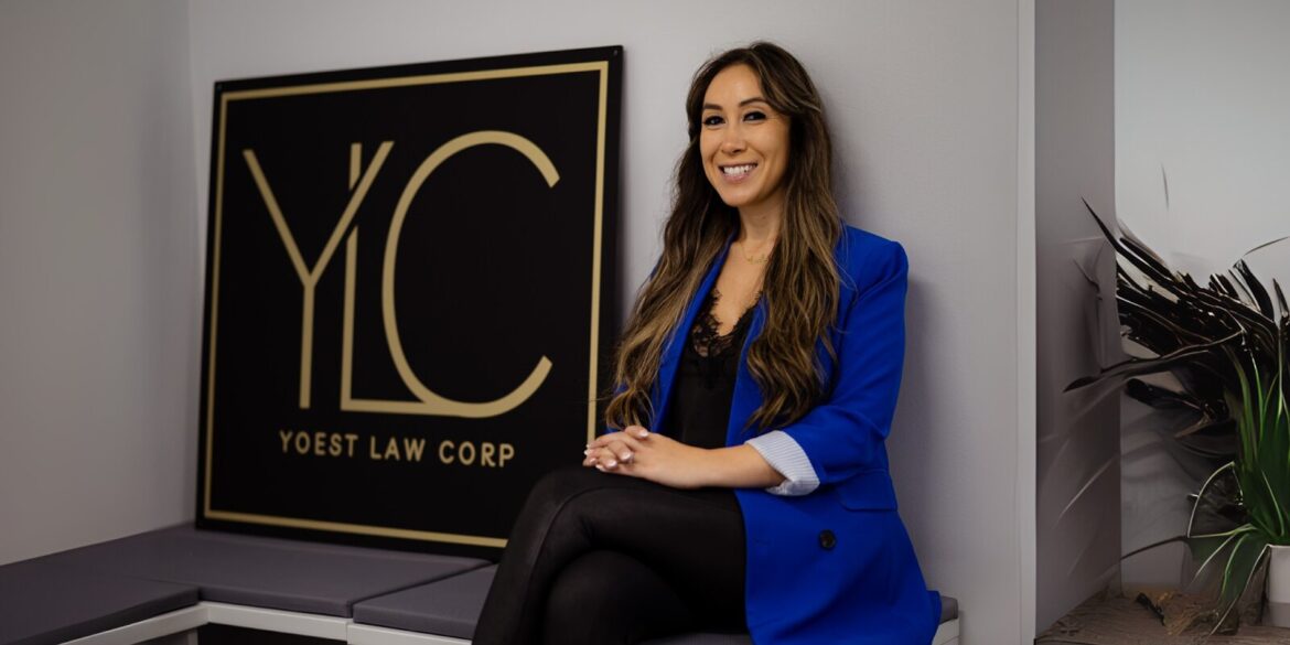 A woman sits on a bench in front of a Yoest Law Corp sign, symbolizing personal legal support and guidance.