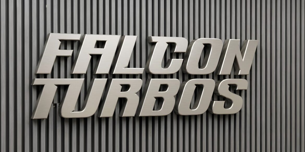 Metallic Falcon Turbos wall logo mounted on vertically ribbed industrial background.