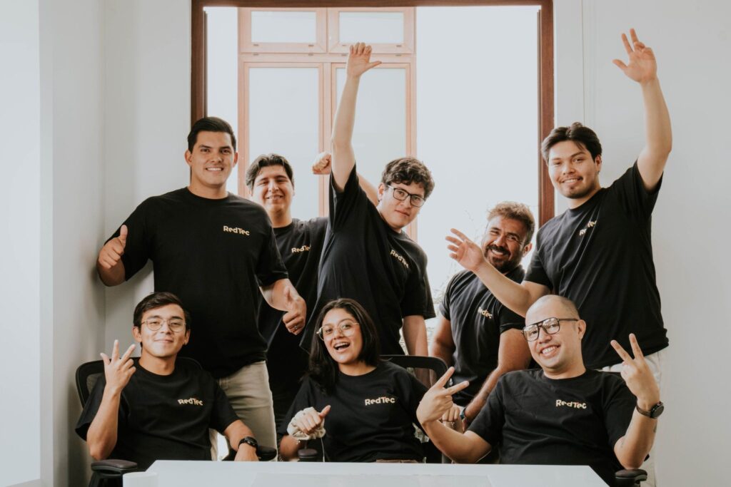 RedTec team members posing together in the company's office.