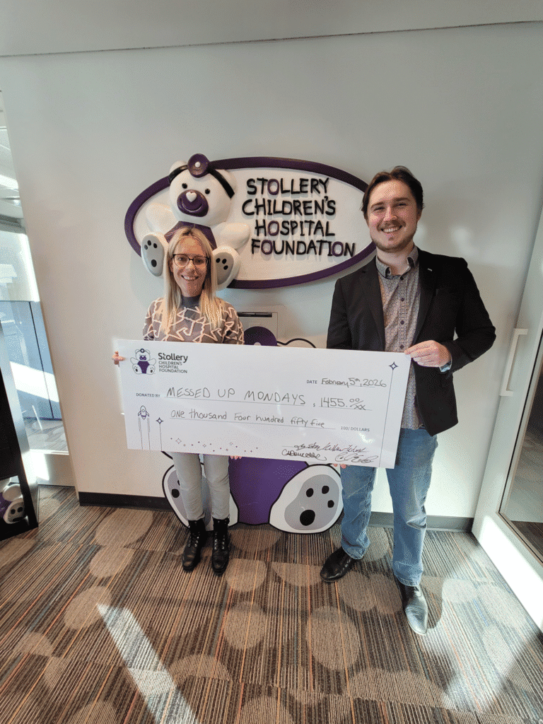 Trystan Keller presents a Stollery Children's Hospital Foundation donation cheque alongside a foundation representative.