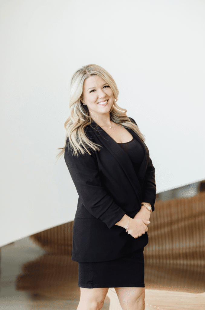 Lauren Foust smiling in a black blazer inside a contemporary office.