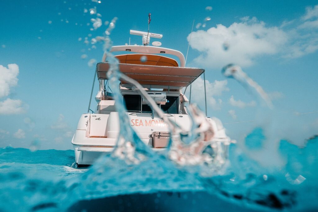 Private motor yacht cruising through turquoise Caribbean water under a bright blue sky.