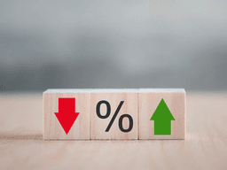 Wooden blocks displaying a red down arrow, percentage sign, and green up arrow